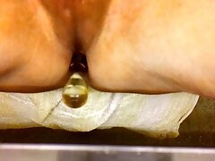 The asshole fucked in close-up with a glass dildo